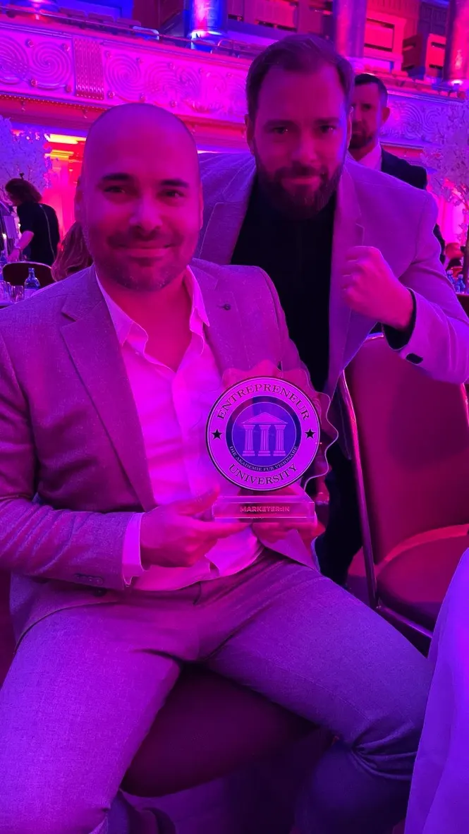 Manuel Lutter mit der Marketer of the Year 2024 Trophäe der Entrepreneur University